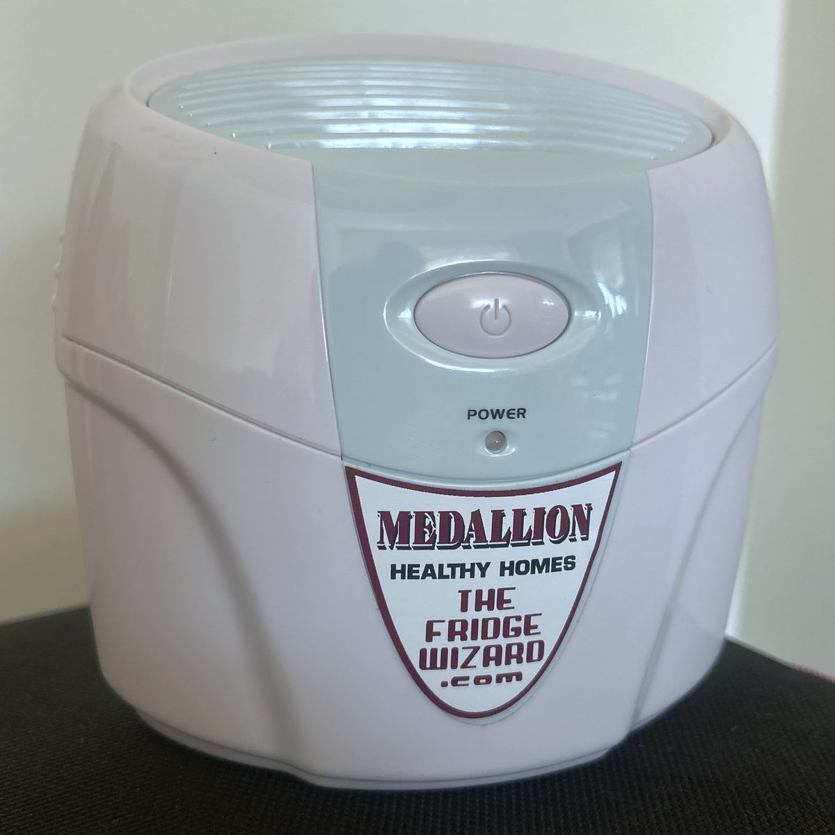 The Fridge Wizard: a compact white fridge ozonator with a power button, power light and a Medallion Healthy Homes / The Fridge Wizard label